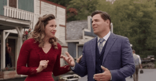 a man and a woman are standing next to each other talking