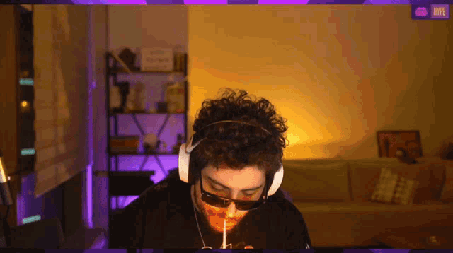 a man wearing headphones and sunglasses is sitting in front of a screen that says skype