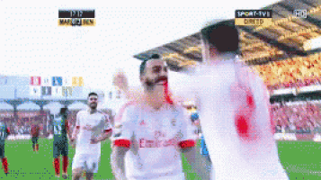 a soccer player wearing a white jersey with emirates written on it