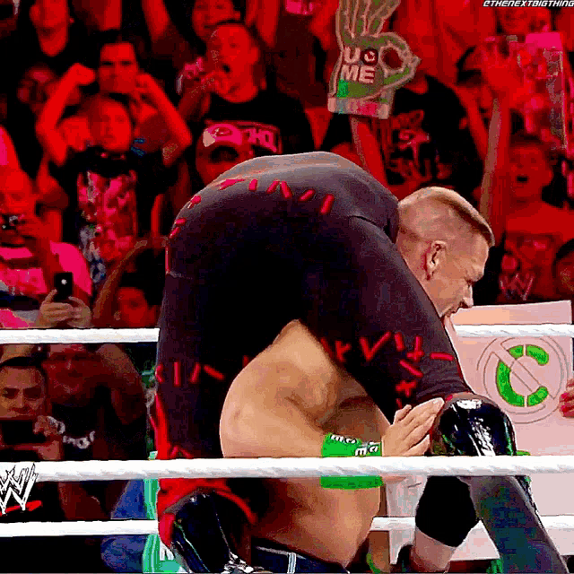 a man in a wrestling ring has a sign that says uc me on it
