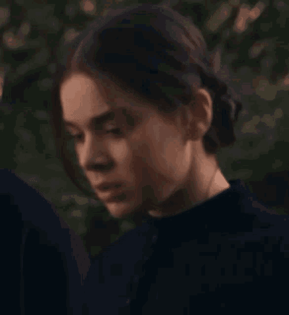 a close up of a woman 's face in a black shirt