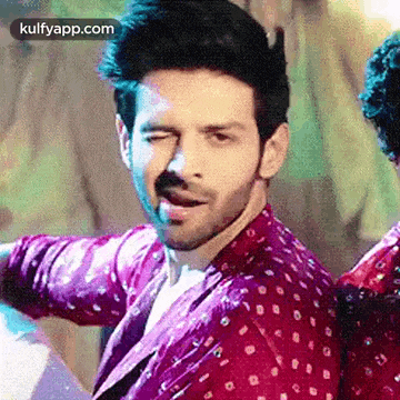 a man in a red shirt is making a funny face while dancing .
