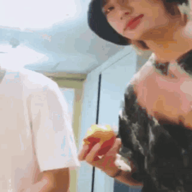 a man in a hat is holding a peach in his hand .