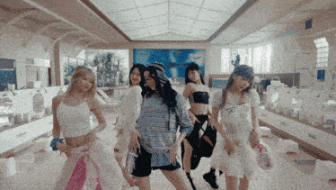 a group of girls are dancing in a bathroom with a painting on the wall behind them