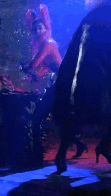 a woman in a red dress is dancing in a dark room