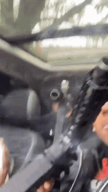 a man is holding a gun in a car while driving down the road