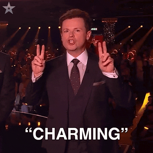 a man in a suit and tie is giving a peace sign with the word charming behind him