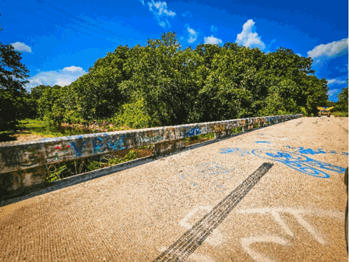 a bridge with graffiti on it and a tire track that says ' ec ' on it
