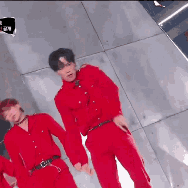 a man in a red shirt is standing next to another man in a red suit