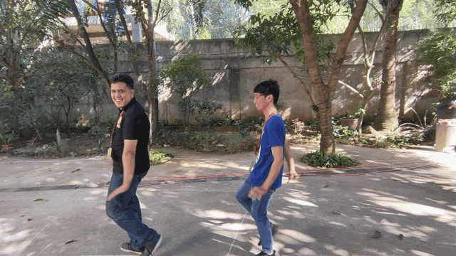 a man in a black shirt and a boy in a blue shirt are walking down a street