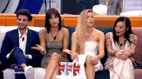 a group of people sitting on a couch with the words grandefratello on the bottom right