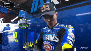 a man wearing a red bull hat is standing in a garage