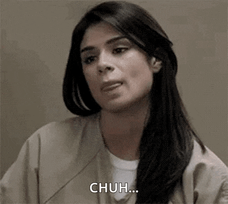 a woman in a jail cell is making a funny face and says chuh .