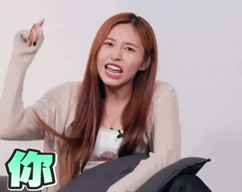 a woman with long red hair is making a funny face with a chinese symbol in the corner