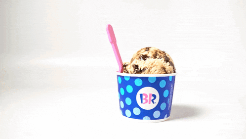 a cup of ice cream with a pink spoon that says br on it