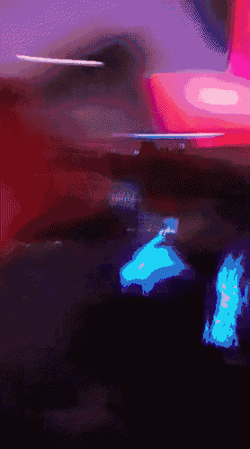 a blurry picture of a red and purple background with a blue light in the middle