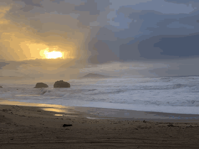 the sun is shining through the clouds over a beach