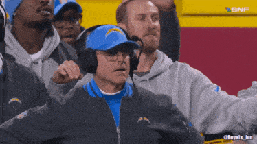 a man wearing a chargers hat and headphones