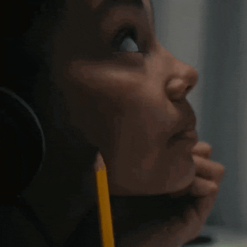 a close up of a person 's face with a pencil in their ear
