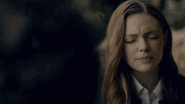 a woman with her eyes closed looks at a man