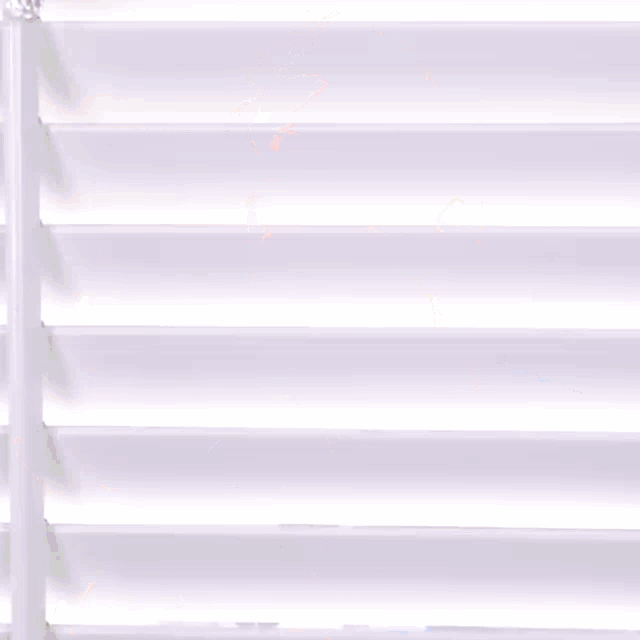 a man with a beard is standing in front of a white wall with his mouth open