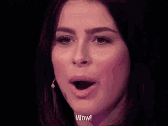 a close up of a woman 's face with her mouth open and the words wow written next to her .