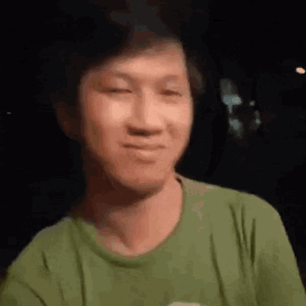 a man in a green shirt is smiling at the camera .