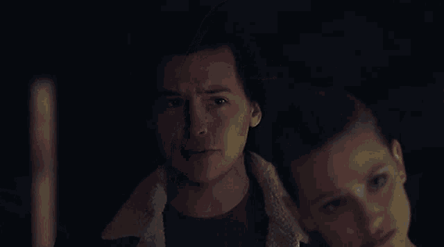 a close up of a woman 's face in a dark room making a funny face .