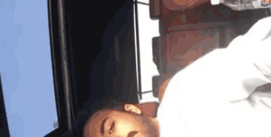 a man is sleeping on a bed in front of a computer monitor .