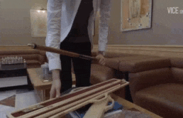 a man in a white shirt is holding a pool cue in a room