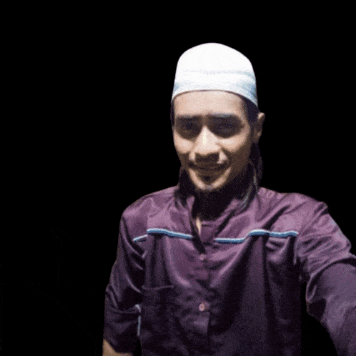 a man wearing a white hat and a purple shirt with the words assalamualaikum above him