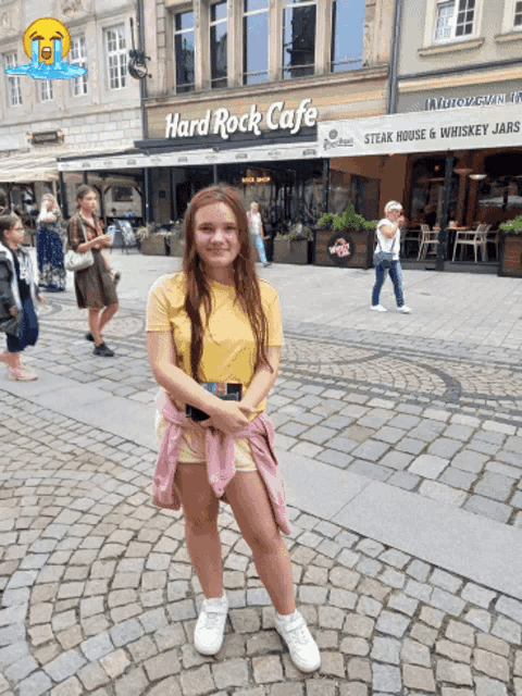 a girl in front of a hard rock cafe