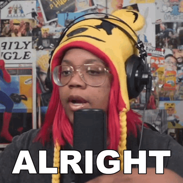 a woman wearing headphones and a tiger hat says " alright "