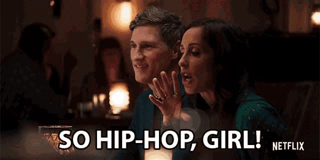 a man and woman are sitting at a table and the woman is saying so hip-hop girl netflix