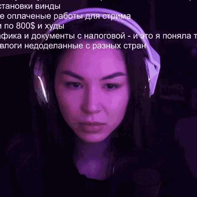 a woman wearing headphones is looking at a screen with russian writing on it