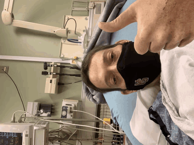 a man in a hospital bed wearing a mask that says usc