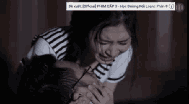 a woman is crying in front of a sign that says " official phim cap 3 - học dương noi loan "