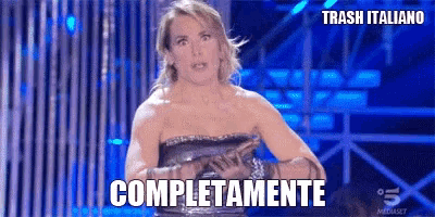 a woman in a strapless dress is standing in front of a sign that says completamente
