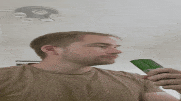 a man is eating a cucumber in front of a sign that says priceless