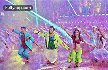 a group of people are dancing on a stage in a crowd .