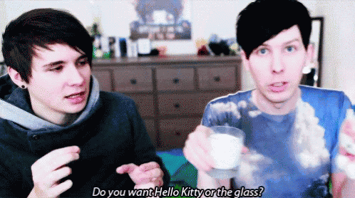 two young men are sitting next to each other and one of them is holding a glass and asking the other if he wants hello kitty
