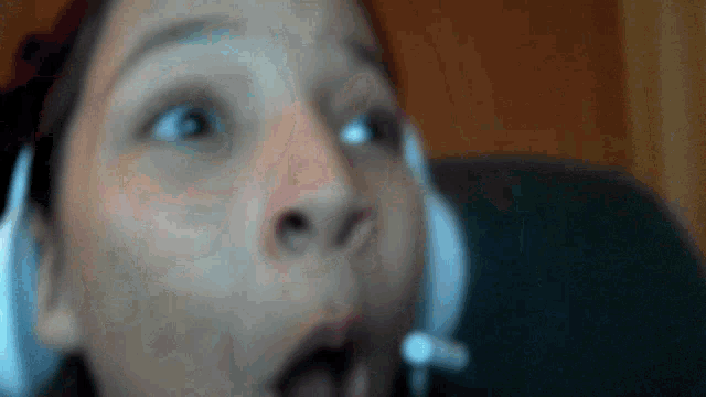a close up of a person 's face with a surprised look on her face