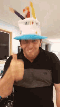 a man wearing a black shirt and a blue hat with the word happy on it