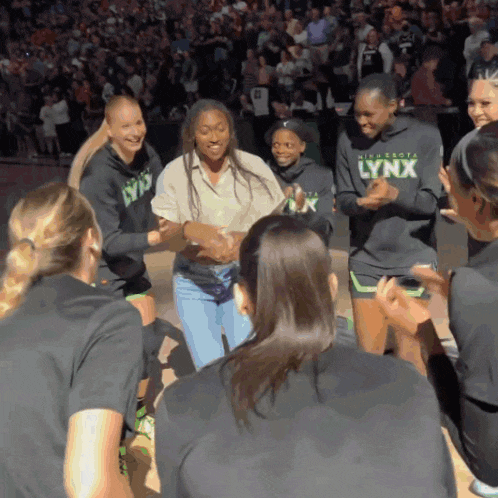 a group of women wearing lynx sweatshirts are clapping