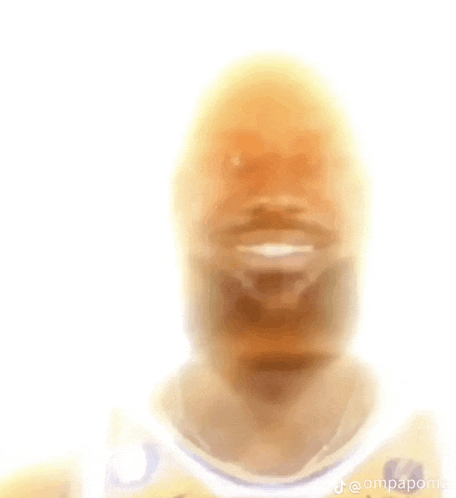 a blurry picture of a man 's face with a smile on his face and a white background .