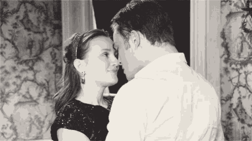 a man and a woman are standing next to each other and kissing .