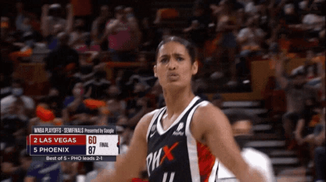 a woman in a phoenix jersey stands in front of a crowd during a game