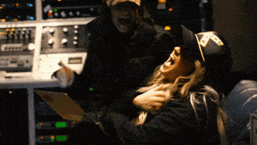 a woman wearing a hat that says ' n.y.c. ' on it laughs