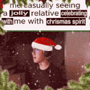 a man wearing a santa hat and headphones is surrounded by christmas trees .