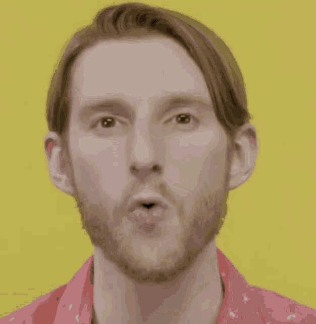 a man with a beard is making a surprised face with his mouth open .